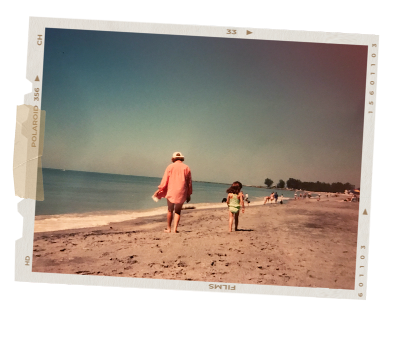 Vintage 90s-style Polaroid photo of a woman and child walking along the beach
